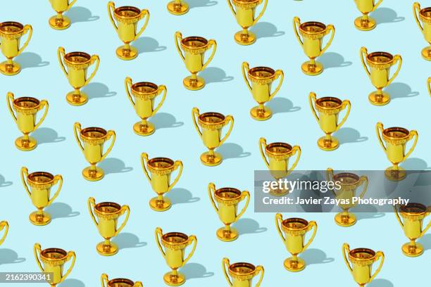 some winner gold cup trophies on blue background - eins zu eins kommunikation stock-fotos und bilder