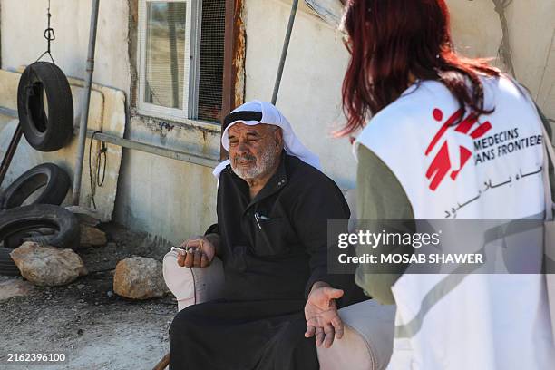 Palestinian Mohamed al-Nawajaa talks with a Doctors Without Borders charity coordinator, in Susya village, in the south of the occupied West Bank,...