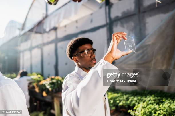 young botanical man analyzing data in the greenhouse - space environment simulation laboratory stock pictures, royalty-free photos & images