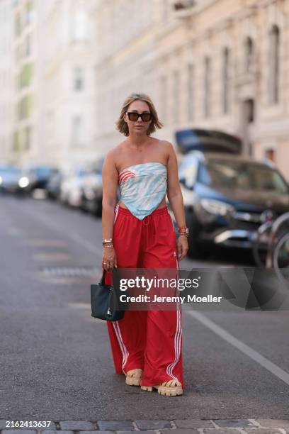 Karin Teigl is seen wearing large black sunglasses; a yellow-gold “Alhambra” necklace with green pendant in cloverleaf shape from Van Cleef & Arpels;...