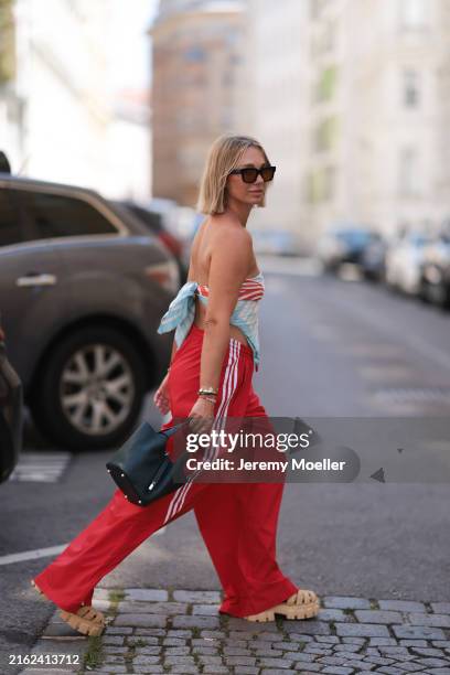 Karin Teigl is seen wearing large black sunglasses; a yellow-gold “Alhambra” necklace with green pendant in cloverleaf shape from Van Cleef & Arpels;...