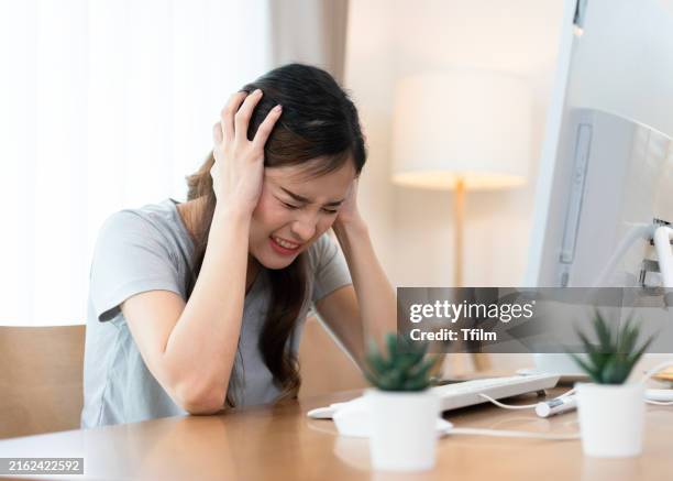 woman frustrated at desk in home office - headache stock pictures, royalty-free photos & images