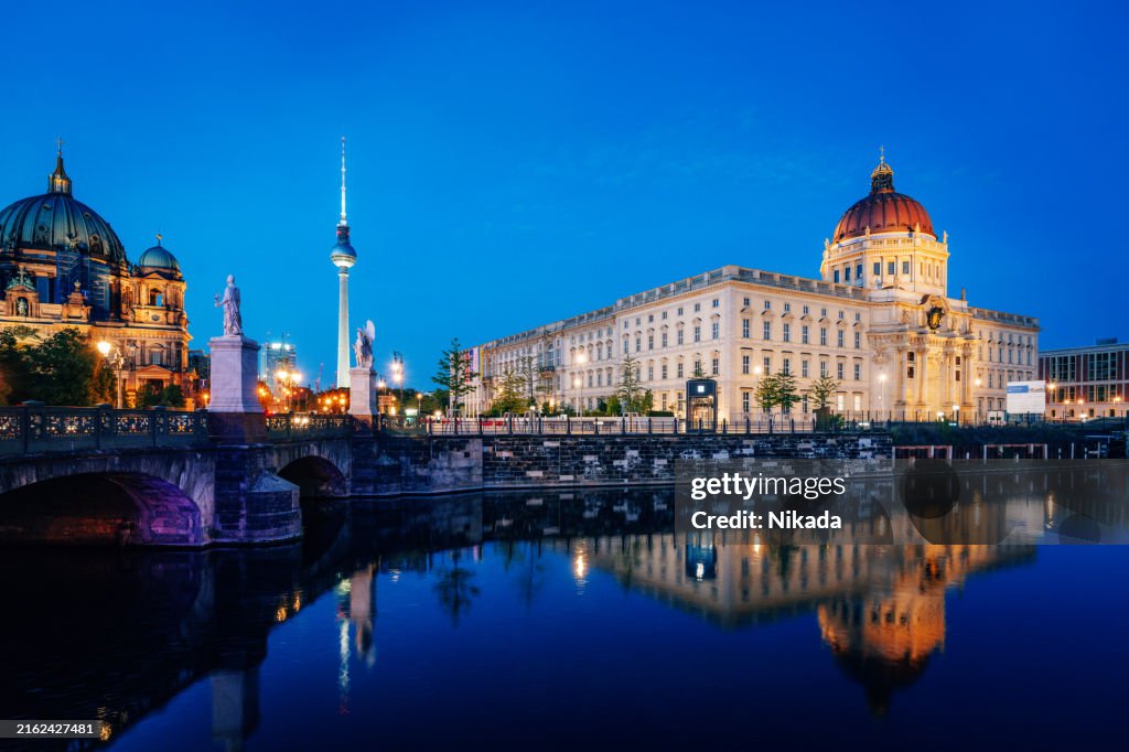 Vista nocturna de la Catedral de Berlín y el Palacio de Berlín reflejándose en el río