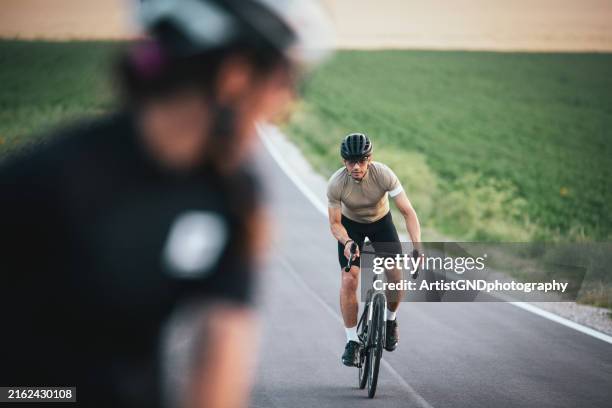 konzentrierter radfahrer, der seine ausdauer auf einem rennrad aufbaut. - rennrad stock-fotos und bilder