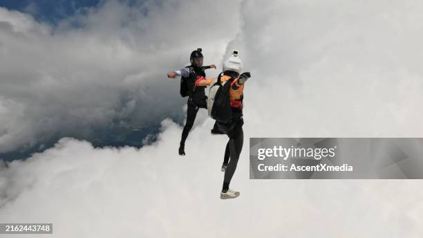 freifallspringer stehen sich in der luft gegenüber - adrenalin stock-fotos und bilder