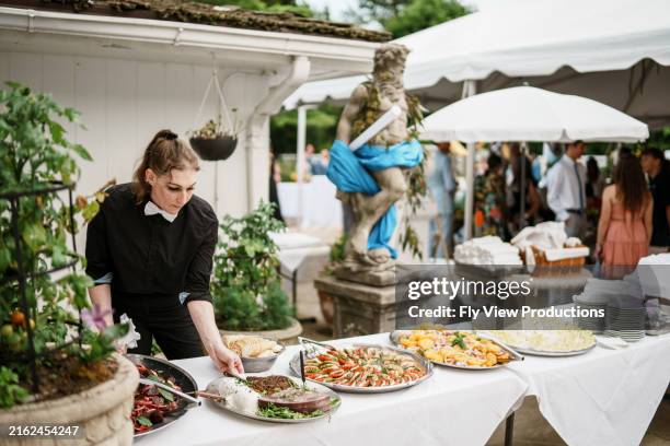 event manager sets up dinner table at wedding reception - catering stockfoto's en -beelden