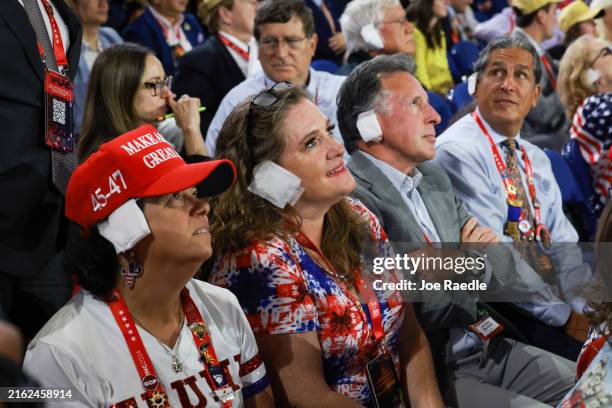 People wear "bandages" on their ears as they watch on the third day of the Republican National Convention at the Fiserv Forum on July 17, 2024 in...