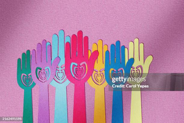 charity and donating, paper cut hands with hearts. - donazione foto e immagini stock