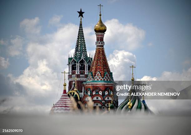 This photograph shows Kremlin's Spasskaya tower and St. Basil's cathedral in downtown Moscow on July 23, 2024.