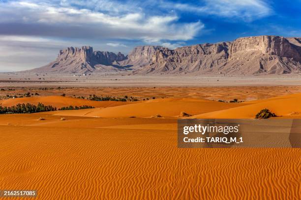 sand dunes in desert in front of tuwaiq mountain landscape, central arabia, saudi arabia - escarpment stock pictures, royalty-free photos & images