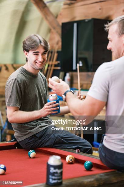 two young man playing pool in man cave - man cave stock pictures, royalty-free photos & images