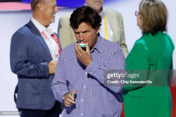 Tucker Carlson holds a pack of nicotine pouches during preparations for the fourth day of the Republican National Convention at the Fiserv Forum on...