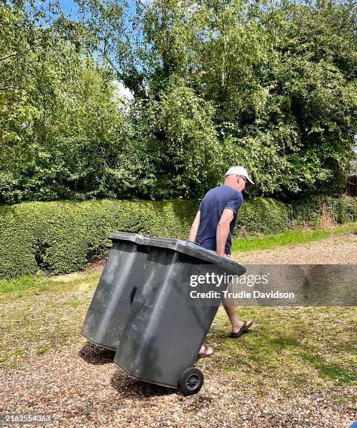 man taking out bins - pattumiera a rotelle foto e immagini stock