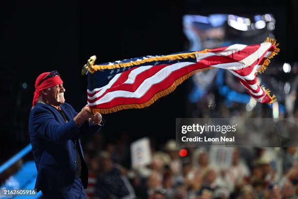 Professional entertainer and wrestler Hulk Hogan waves an American flag as he arrives to speak on the fourth day of the Republican National...