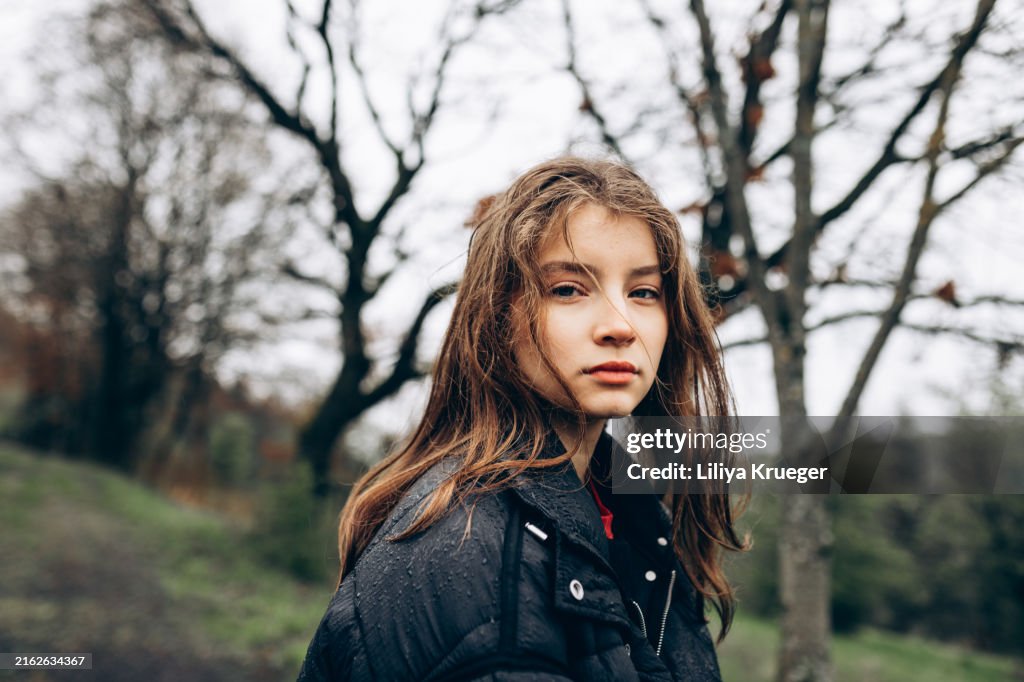 Close-up portrait of a beautiful young girl walking in the forest.