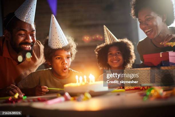 make a wish and blow your birthday candles! - kid blowing out candles photos et images de collection