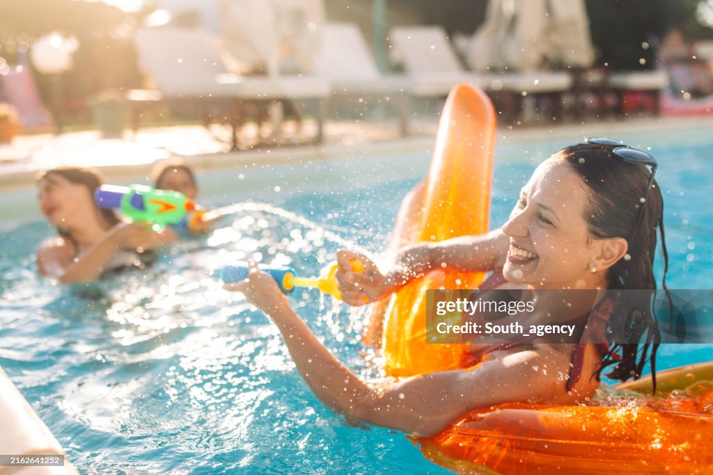 Cheerful Mother and Children Having a Blast with Waterguns