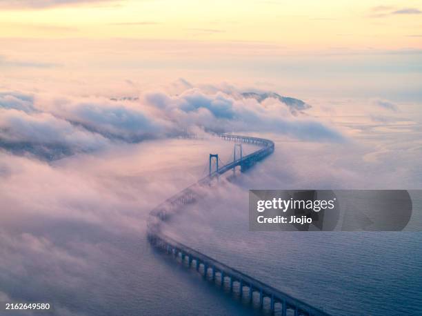 bridge shrouded in fog at sunrise - severe weather clouds stock pictures, royalty-free photos & images