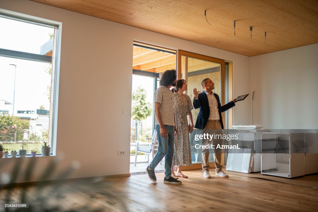 Hispanic Real Estate Agent Guides Homebuyers During Viewing