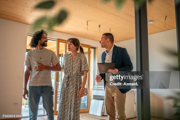 hispanischer immobilienmakler mit kunden in home viewing - immobilienbegehung stock-fotos und bilder