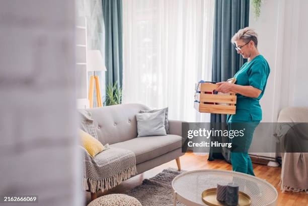 mitarbeiter des gesundheitswesens hebt organisierte box in hellem raum. - box lifting technique stock-fotos und bilder