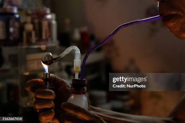 Someone is smoking crystal meth out of a pipe before meeting someone for a chemsex encounter at their home in Bangkok, Thailand, on July 24, 2024....