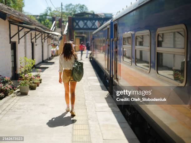 woman boarding the train in ella during her trip in sri lanka - u bahnstation stock-fotos und bilder