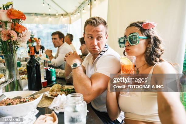bride and groom having a good time at the wedding party dinner - fake smile couple stock pictures, royalty-free photos & images