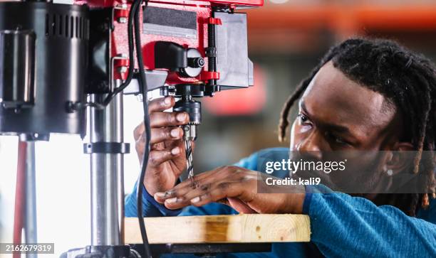 african-american worker setting up drill press - drill press stock pictures, royalty-free photos & images