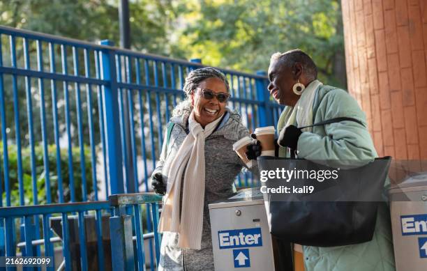 two senior black women exiting train station, talking - disposable cup stock pictures, royalty-free photos & images