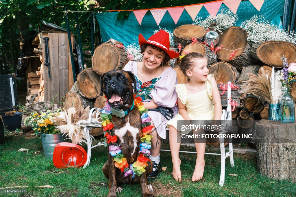 Young girl, her nanny and their boxer dog dressing up at the wedding party