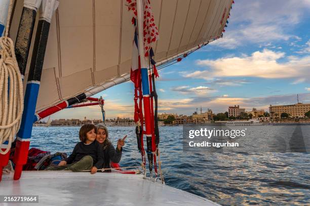 mother and son travel on a felucca boat in luxor. - rio nilo imagens e fotografias de stock