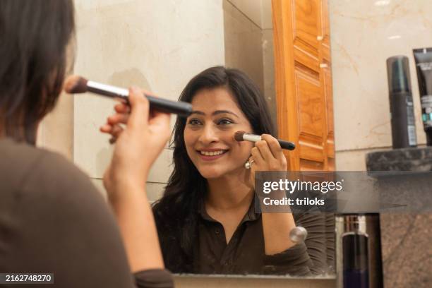 happy woman applying eyeshadow with brush at home - indian eye makeup imagens e fotografias de stock