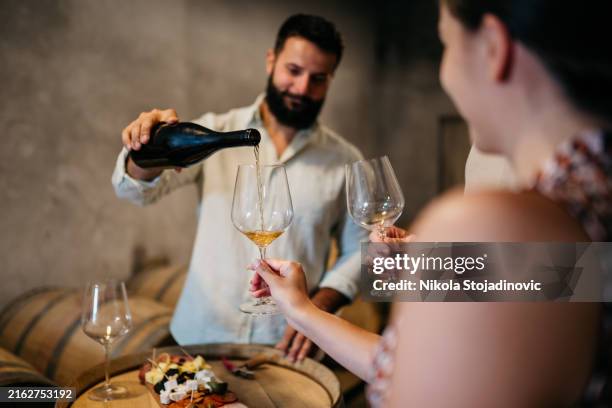 drinking wine in a wine cellar - wijnkelder stockfoto's en -beelden