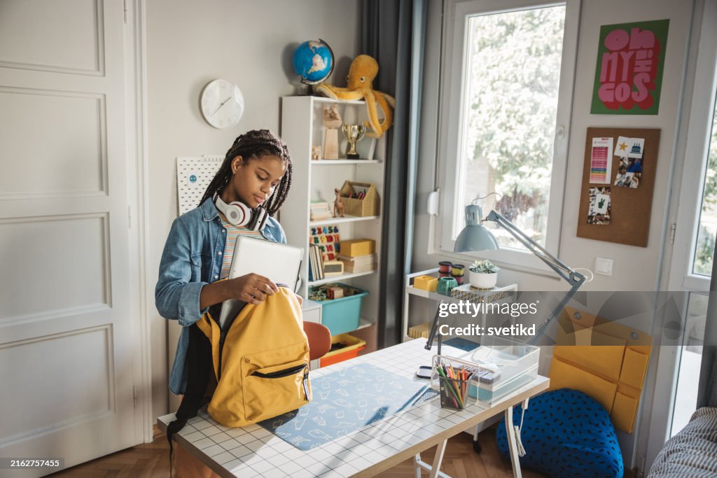 Teenage girl packing for school
