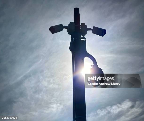 surveillance cameras in silhouette backlit sun - conspiracy theory stock pictures, royalty-free photos & images