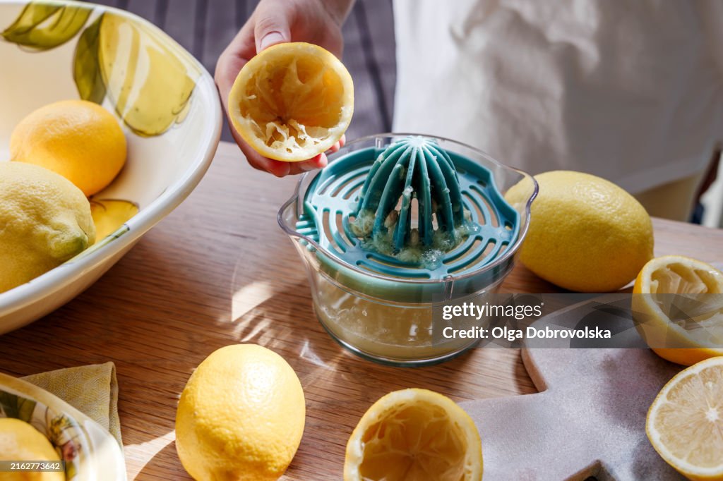 A boy squeezing a lemon on a hand juicer in a kitchen