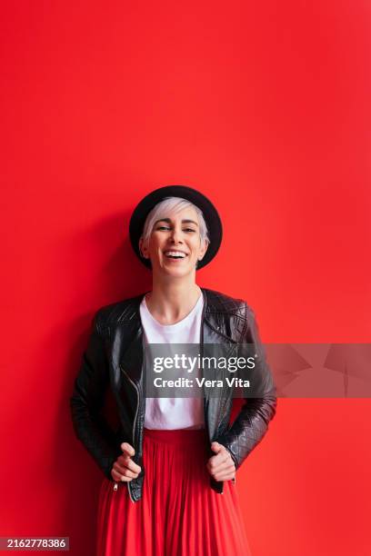 portrait of european woman looking at camera on red background - red jacket stock pictures, royalty-free photos & images