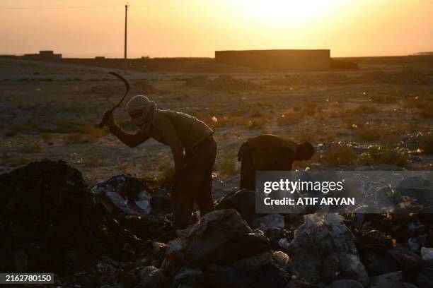 Afghan boys search for recyclable materials at a garbage dump on the outskirts of Mazar-i- Sharif on July 25, 2024.