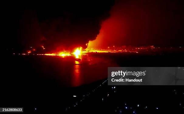 In this handout screengrab released by the Houthi group Media Center on July 20 a fire rises after airstrikes carried out by Israeli warplanes...