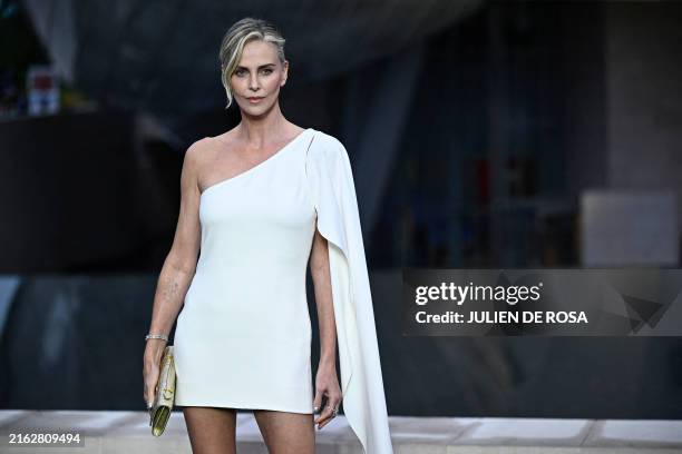 South African actress Charlize Theron poses on the red carpet as she arrives for 'The Prelude to the Olympics' at The Fondation Louis Vuitton in...