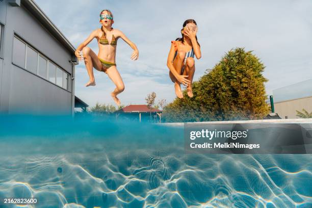 summer fun jumping in the pool - young girl jumping into swimming pool stock pictures, royalty-free photos & images