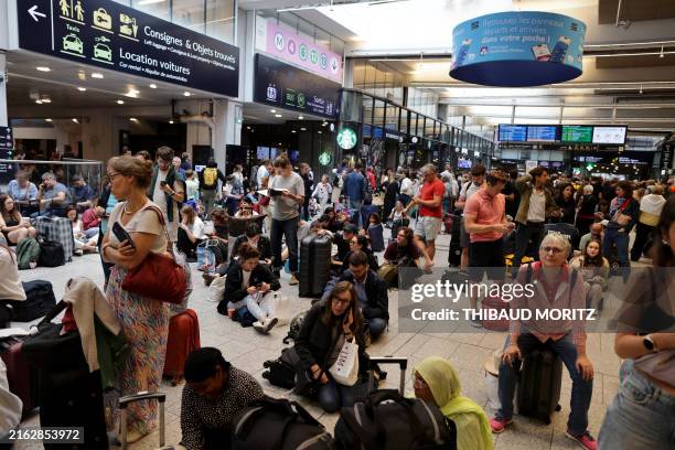 Passengers wait for their train departures at the Gare Montparnasse train station in Paris on July 26, 2024 as France's high-speed rail network was...