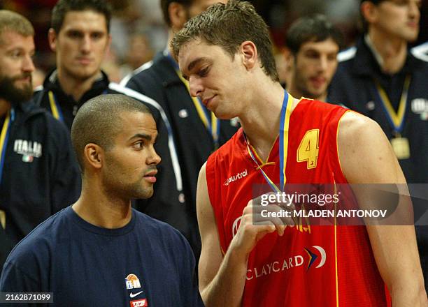 Spain's Pau Gasol talks to France's Tony Parker after receiving his medal for best scorer, 14 September 2003 after the final of the men's FIBA 2003...