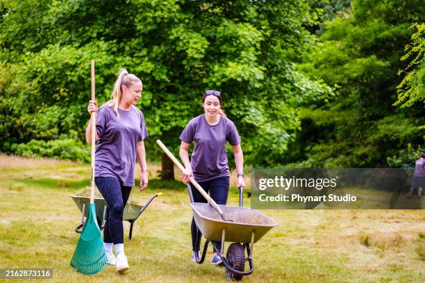 a communal effort towards maintaining or improving a natural space, fostering a sense of environmental stewardship and collaboration. - wheelbarrow stock pictures, royalty-free photos & images