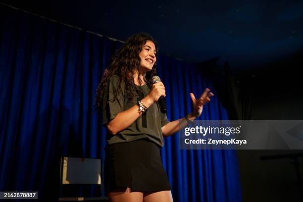 young woman using microphone at stage, stand up comedian - achter de schermen begrippen stockfoto's en -beelden