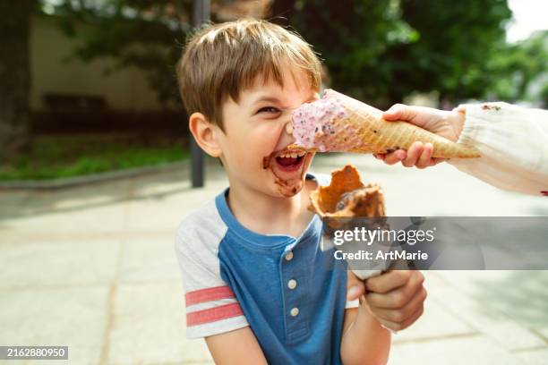 cute children having fun with ice-cream in summer park - girl eating messy ice cream cone stock pictures, royalty-free photos & images