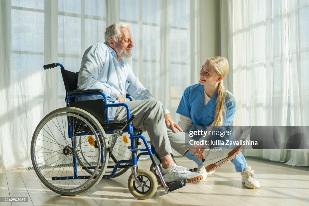 Help support retirement healthcare. Nurse helping old man in wheelchair. Patient and woman in nursing home for medical caregiver, Nurse taking care of paralyzed man in chair for people with disability