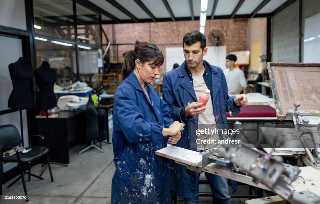 Team of designers printing textiles in a fashion design class