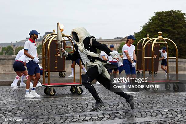 Torchbearer runs past Pont Neuf during the opening ceremony of the Olympic Games Paris 2024 on July 26, 2024 in Paris, France.